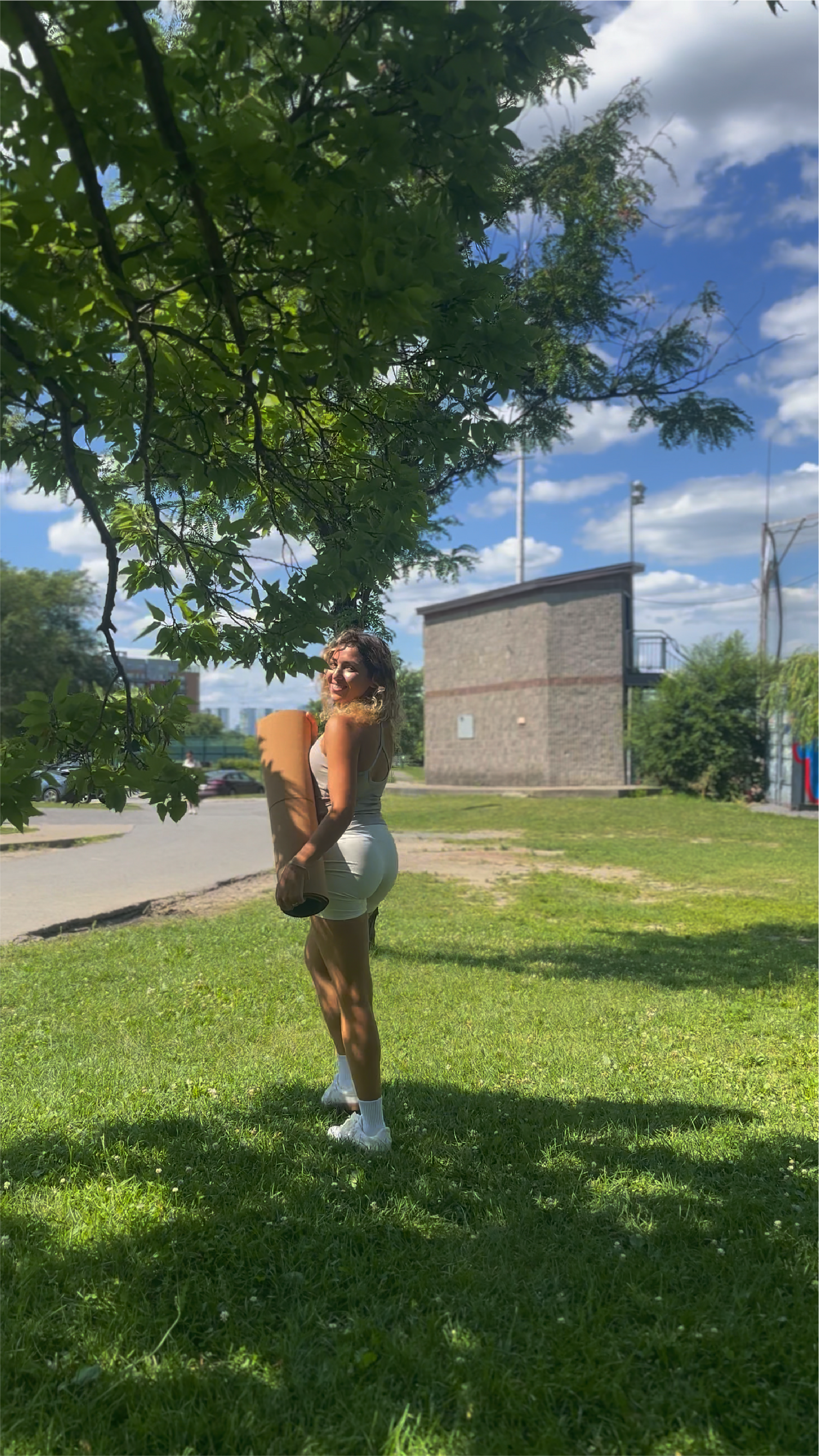 Girl who just won a crk cork yoga mat outside on a sunny day in a park